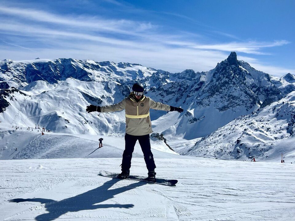 Harry snowboarding down the slopes of Val Thorens, surrounded by snowy peaks in Les 3 Vallées, France