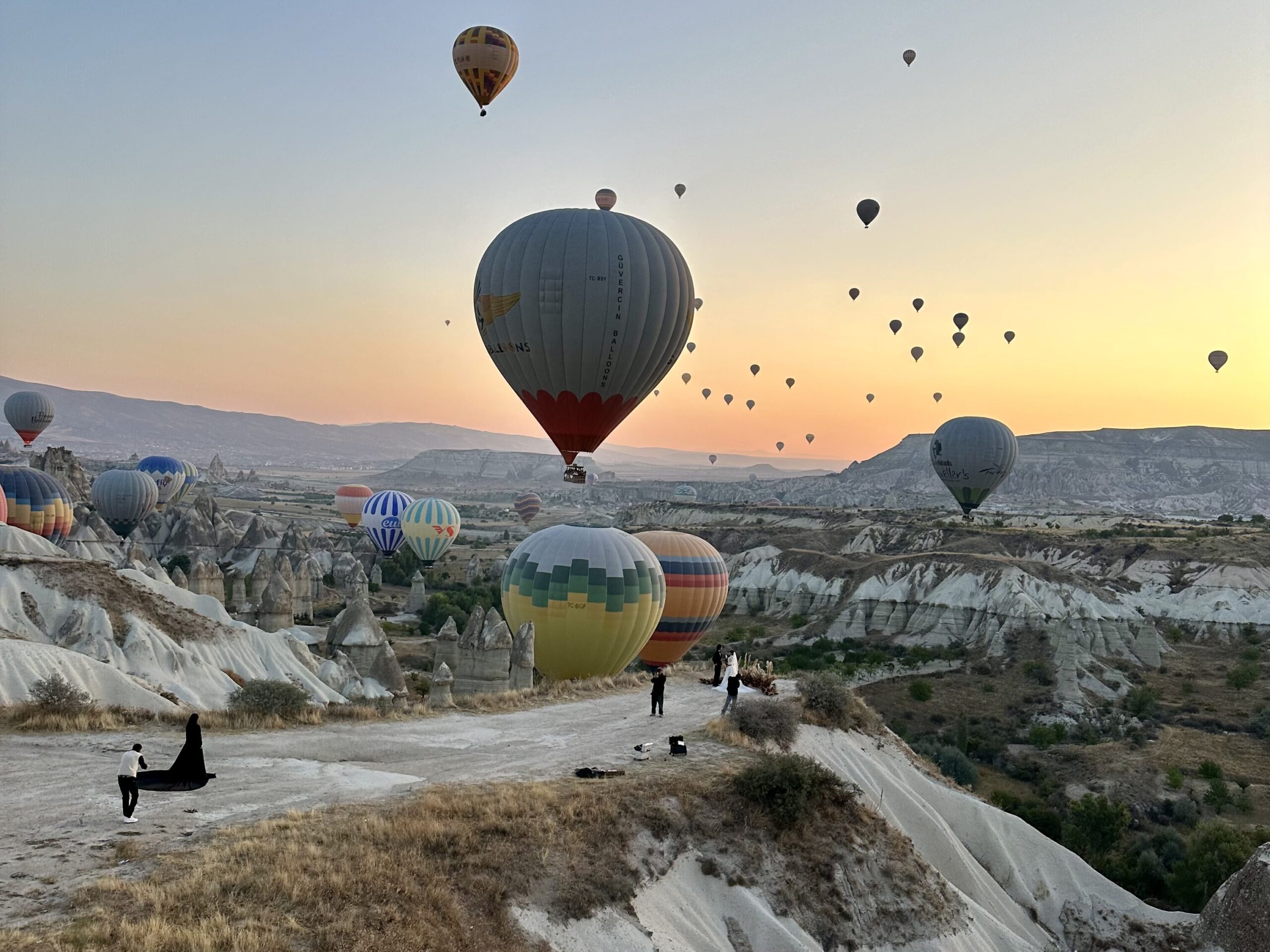 Hot air balloons floating over the unique rock formations of Cappadocia, Turkey, at sunrise